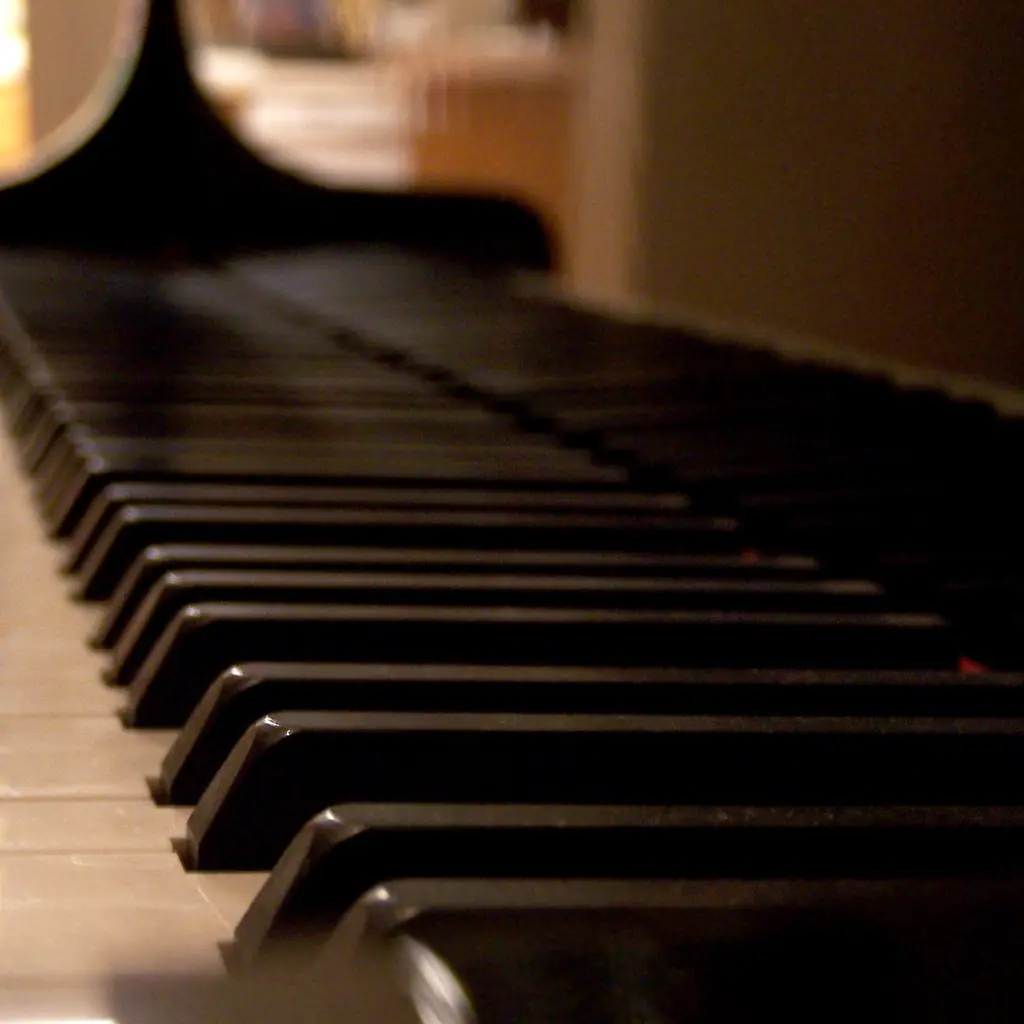 Piano keys lit by warm light.