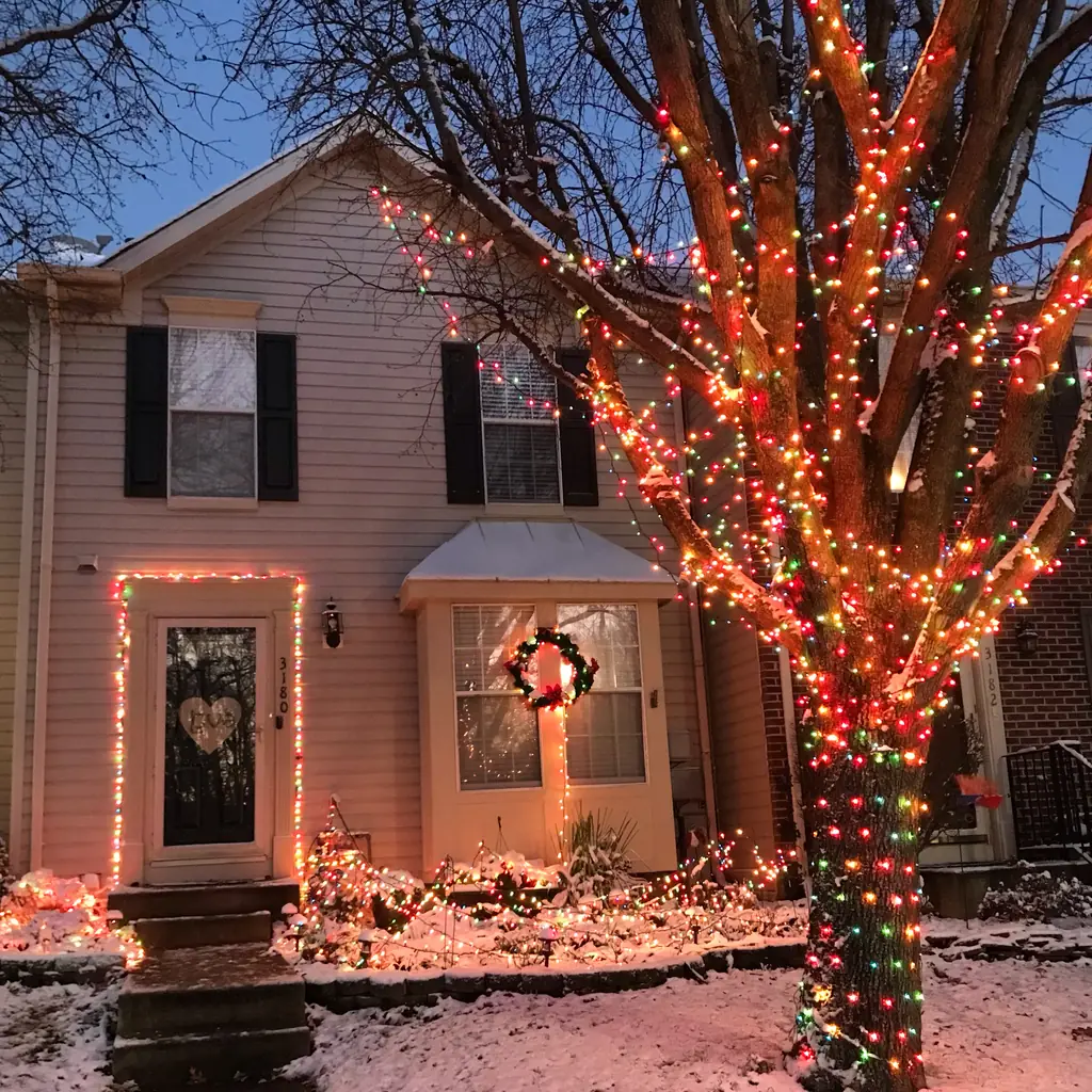 A house lit with Christmas lights in the first snow of the season.